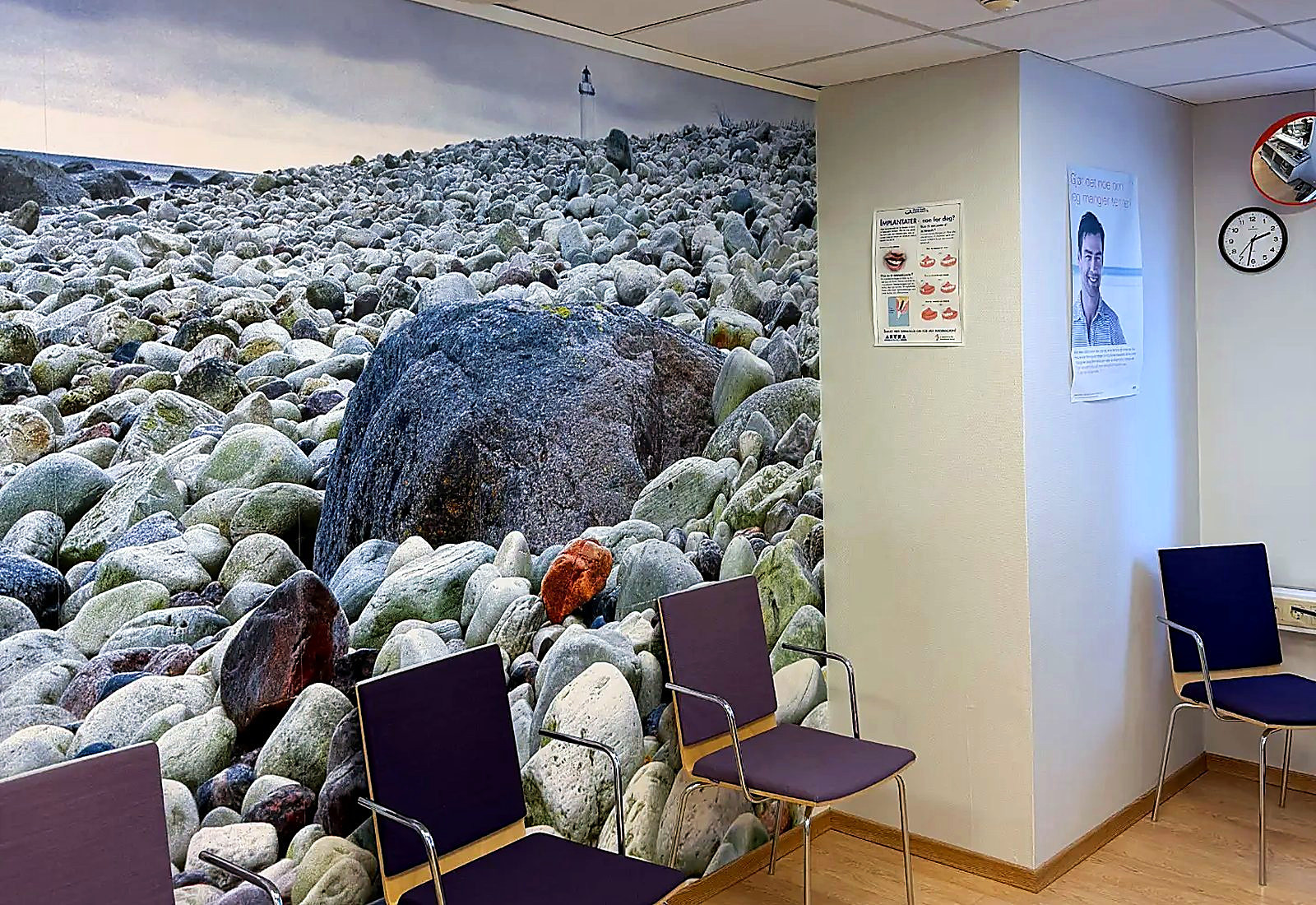 Venterommet hos kjevekirurgen i Tønsberg, med stor veggmural av en steinstrand og lilla stoler